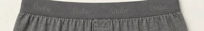 The boxer waistband across its full width: Ümbe woven tonally into the charcoal elastic four times over, readable only where the light catches it.