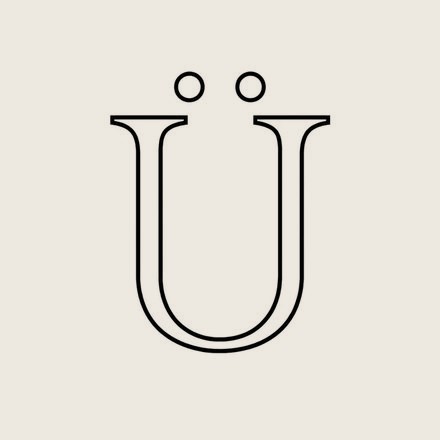The Ümbe Ü mark as drawn: a wide U with two circular dots above it, in a single fine weight.